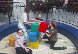 Dziewczęta budują konstrukcję z klocków geometrycznych