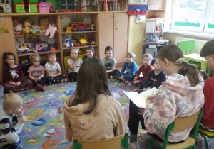 Wolontariusze czytają bajkę przedszkolakom