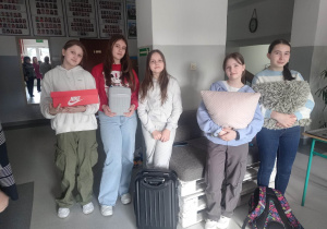 Dziewczynki z klasy szóstej ze swoimi plecakami- walizką, pudełkiem po butach i poduszkami.