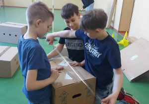 Chłopcy przygotowują pudełka do zajęć