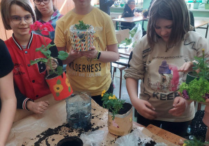 Uczniowie klasy Va sadzą rośliny w doniczkach z odpadów