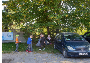 Uczniowie sprzątają teren parkingu