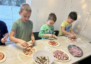Chłopcy tworzą pizzę według swojego pomysłu