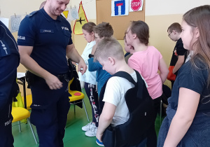 Uczeń przymierza kamizelkę policjanta
