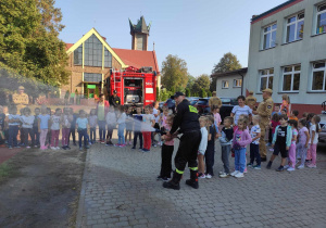 Dzieci ćwiczą używanie węża strażackiego