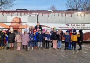 Dzieci stoją przed " czekoladowym autobusem".