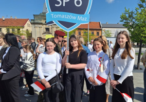 Dziewczynki z klas piątych z tarczą szkoły podczas uroczystości