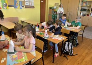 Uczniowie klasy Ib ozdabiają zrobione przez siebie namioty tipi.