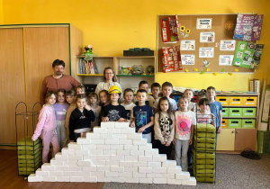 Uczniowie klasy Ia z prowadzącymi zajęcia stoją za murem, który zbudowali.