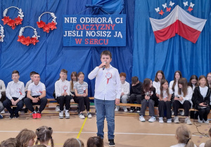 Jeden z uczniów recytuje wiersz przed zebranymi