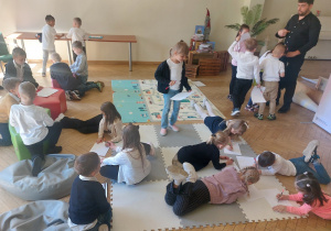Przedszkolaki rysują leżąc na podłodze