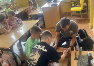Chłopcy pomagają Panu Stańdo budować budkę dla ptaków.