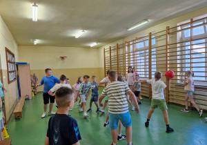 Dzieci grają w sali gimnastycznej.