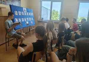 Uczniowie klasy VIIIa słuchają fraszek Jana Kochanowskiego, które czyta jeden z chłopców.