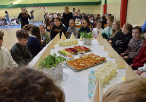Uczniowie klasy IVa siedzą przy stole.