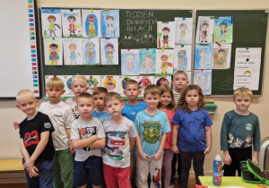 Dzieci z grupy "0" na tle swoich prac plastycznych.