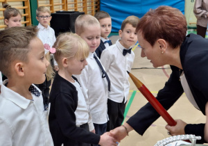 Pani Barbara Klatka gratuluje uczennicy klasy pierwszej.