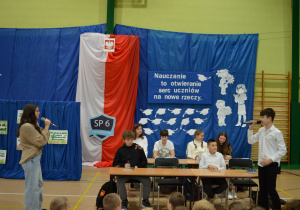 Uczniowie odgrywają scenkę o lekcji w szkole.
