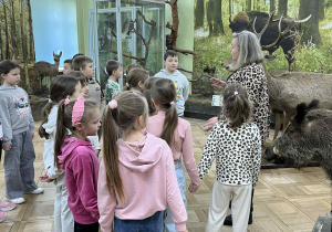 Dzieci podziwiają eksponaty przyrodnicze.