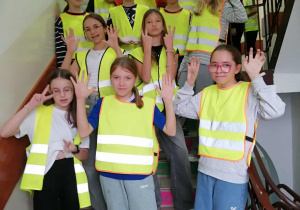Klasa VIb na schodach w kamizelkach odblaskowych.