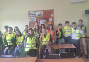 Uczniowie klasy VIIb w pracowni informatycznej w kamizelkach odblaskowych