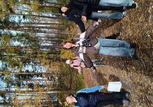 Uczniowie wykonują ćwiczenia oddechowe w lesie.