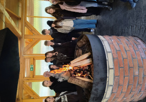 Uczestnicy wyprawy stoją wokół ogniska.