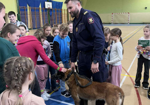 Dzieci głaszczą psa.