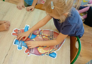 Dzieci układają serce z puzzli.