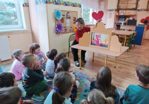 Pani bibliotekarka z teatrzykiem kamishibai w przedszkolu.