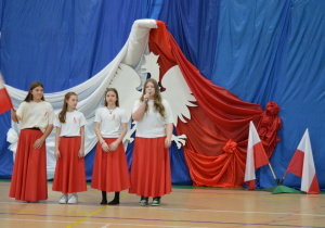Dziewczynki w biało- czerwonych strojach mówią na apelu.